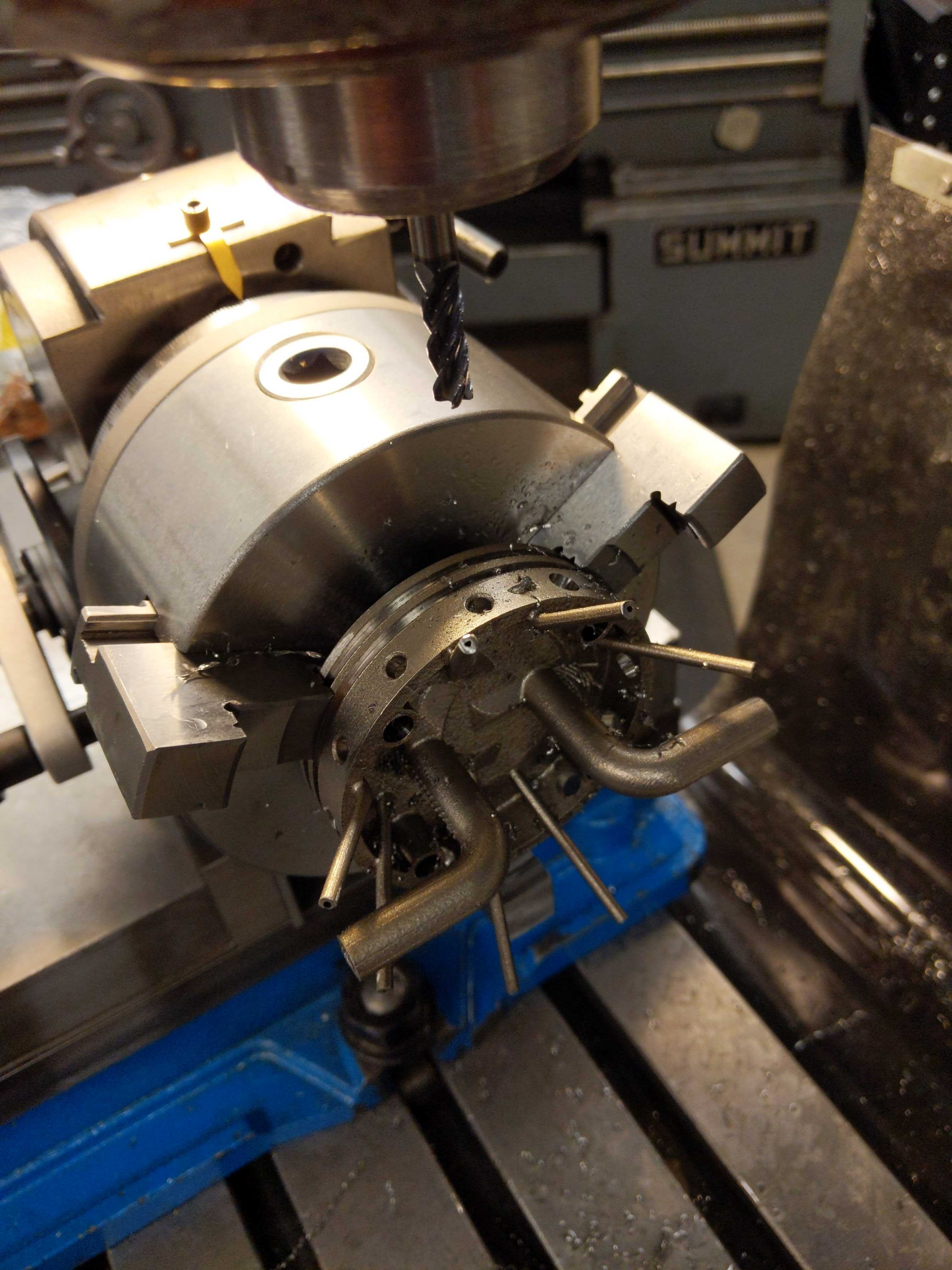 Manual mill drilling a nozzle pin hole in the injector